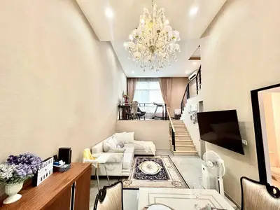 Luxurious living room with high ceiling, elegant chandelier, and stylish mezzanine in modern apartment.