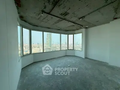 Spacious corner unit with panoramic city views from large windows in a high-rise building.