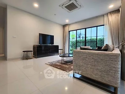 Spacious modern living room with sleek furniture and large window view.