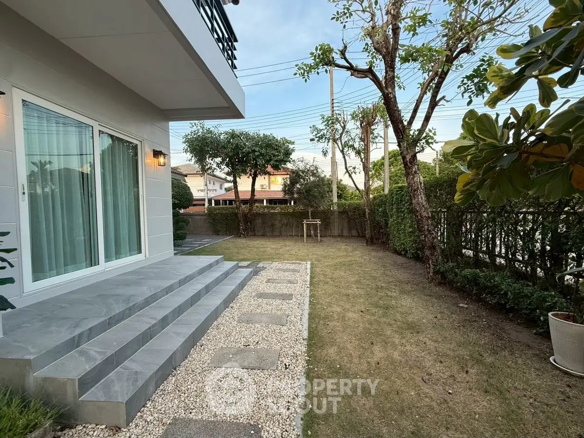 Charming garden view with modern patio and lush greenery, perfect for outdoor relaxation.