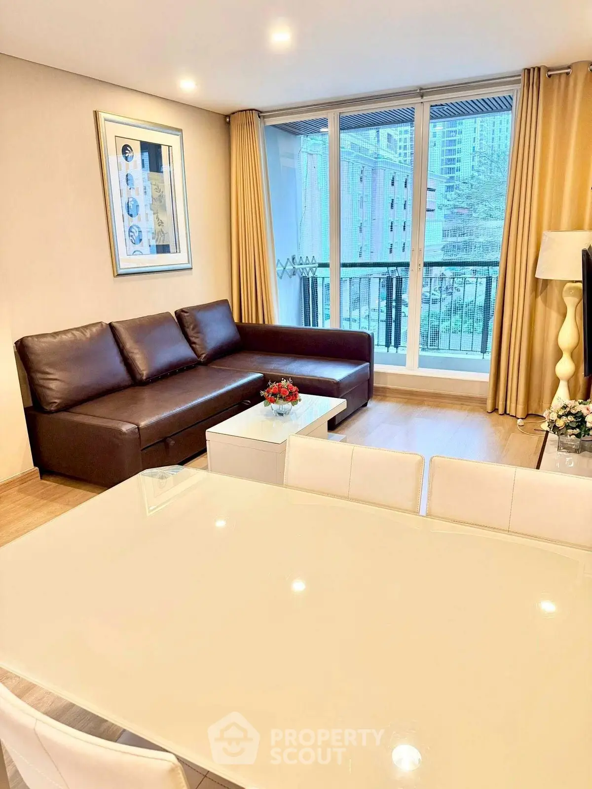 Spacious living room with modern furniture and large windows offering city views.