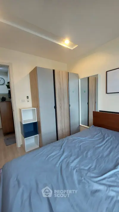 Modern bedroom with stylish wardrobe and cozy bed in contemporary apartment.