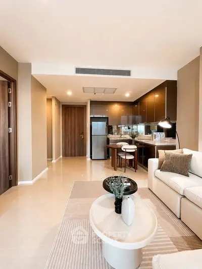 Modern open-plan living room with stylish kitchen and cozy seating area in a contemporary apartment.