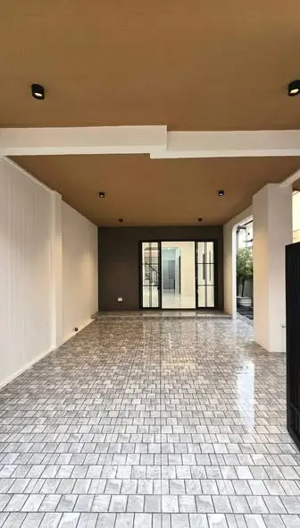 Spacious covered parking area with modern tiled flooring and recessed lighting.