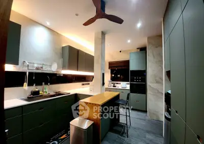 Modern kitchen with sleek cabinetry and central island, featuring a ceiling fan and stylish lighting.