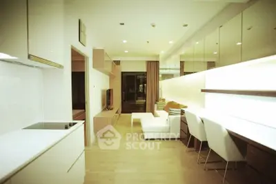 Modern living room with sleek design and open layout, featuring white furniture and wooden accents.