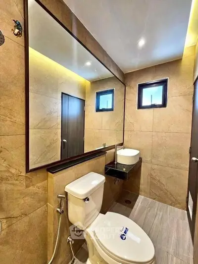 Modern bathroom with sleek fixtures and large mirror in luxury home.