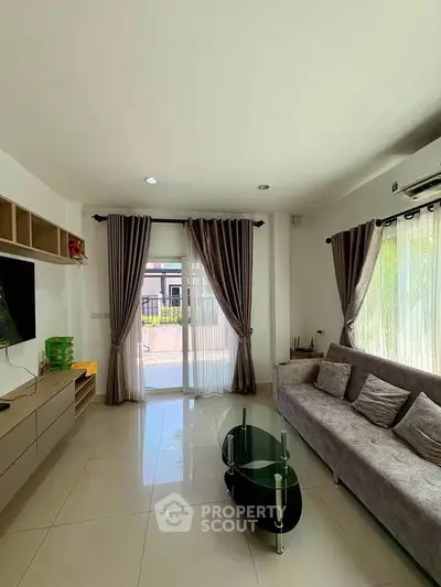 Modern living room with sleek furniture and large windows offering natural light.