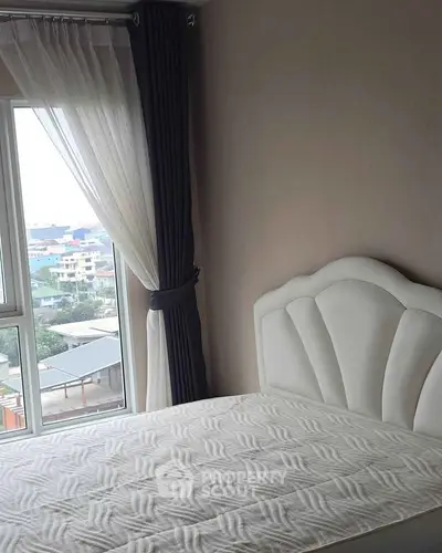 Bright bedroom with large window and elegant headboard, offering a serene city view.
