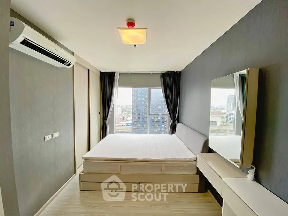 Modern bedroom with city view, featuring sleek design and ample natural light.