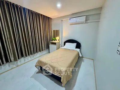Cozy bedroom with modern air conditioning and elegant curtains, perfect for a restful night's sleep.