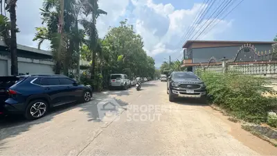 Charming suburban street view with lush greenery and modern architecture.
