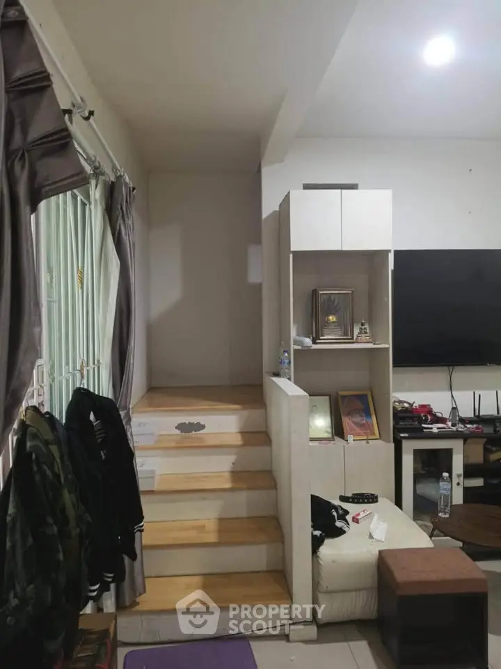 Cozy living room with modern staircase and entertainment center