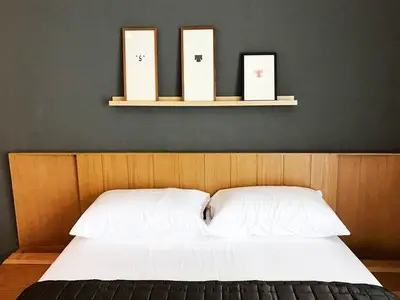Modern bedroom with stylish wooden headboard and minimalist wall art