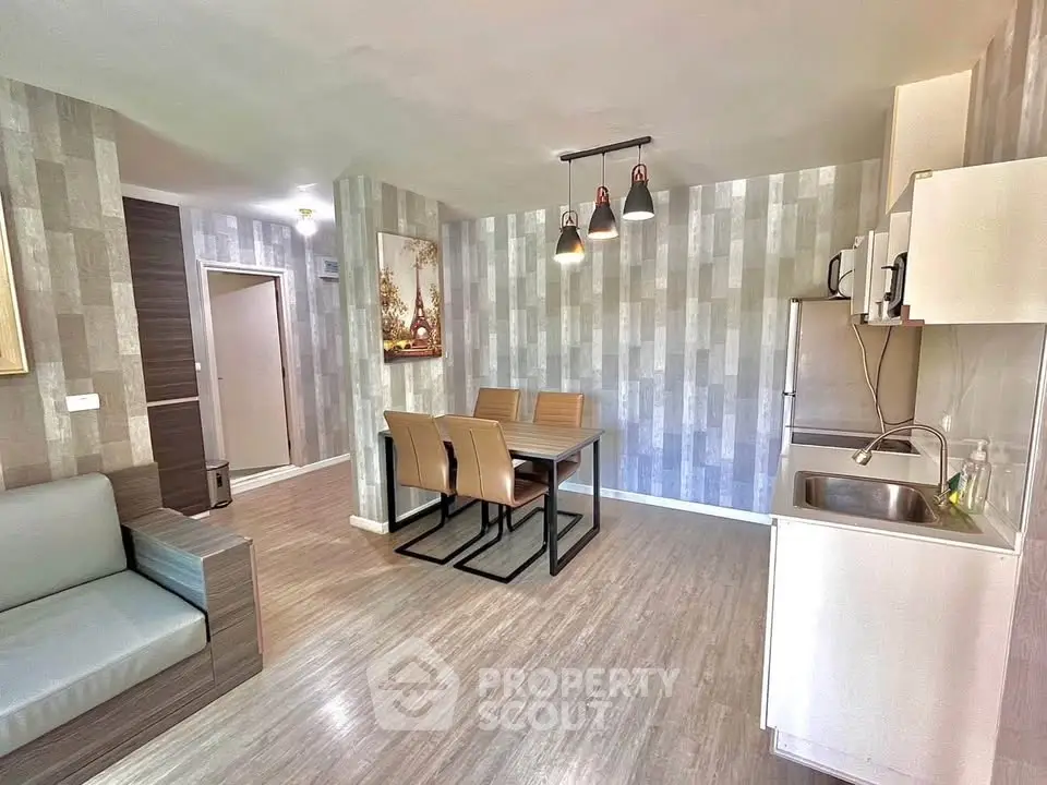Modern open-plan living room with dining area and compact kitchen in stylish apartment.