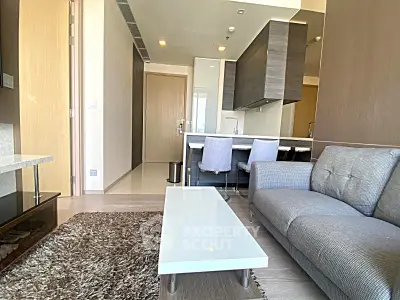 Modern living room with sleek furniture and open kitchen layout in a stylish apartment.