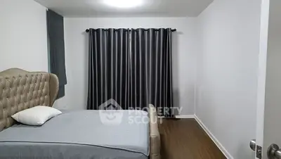 Spacious bedroom with elegant bed and dark curtains, perfect for relaxation.