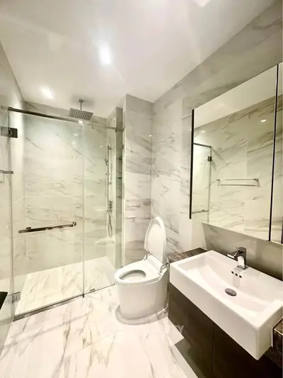 Luxurious modern bathroom with marble tiles and glass shower enclosure