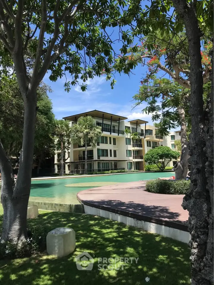Luxurious apartment building with lush garden and serene pool view, perfect for modern living.