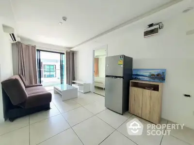 Modern living room with sleek furniture and natural light, featuring a compact fridge and stylish decor.