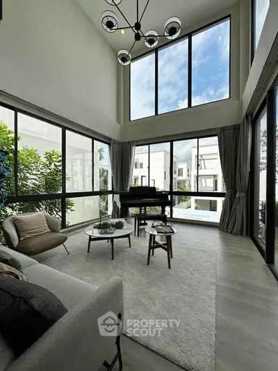 Stunning modern living room with high ceilings and large windows offering abundant natural light.