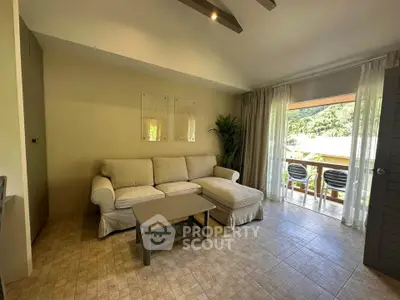 Cozy living room with comfortable sofa and balcony view, perfect for relaxation and enjoying nature.