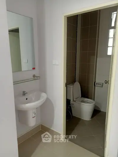 Modern bathroom with sleek design featuring a pedestal sink and tiled walls.