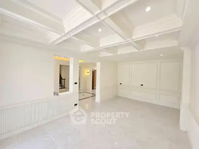 Spacious and elegant living room with coffered ceiling and marble flooring
