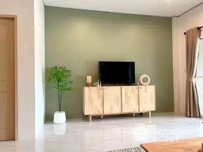 Modern living room with stylish wooden TV stand and green accent wall