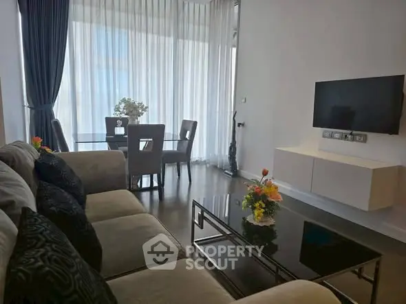 Modern living room with elegant decor and large windows offering natural light.