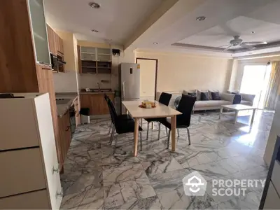 Spacious open-plan kitchen and living room with modern furnishings and marble flooring.