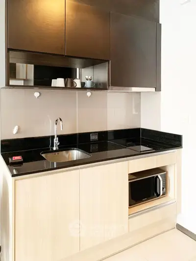 Modern compact kitchen with sleek cabinetry and built-in microwave