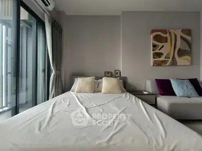 Modern bedroom with large window and stylish decor in a contemporary apartment.