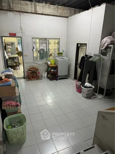 Spacious laundry room with washing machine and ample storage space in a residential property.