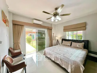 Spacious bedroom with garden view and modern decor in a luxurious home.