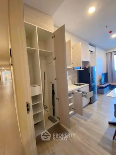 Modern apartment interior with open kitchen cabinets and sleek appliances.