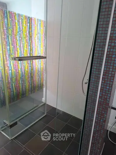 Modern bathroom with colorful glass partition and sleek shower design