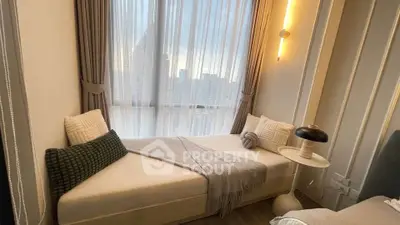 Cozy bedroom with a stylish daybed and city view through large windows, perfect for relaxation.