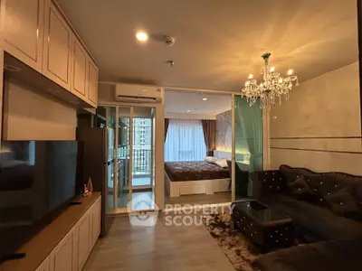 Luxurious modern living room with elegant chandelier and cozy bedroom view