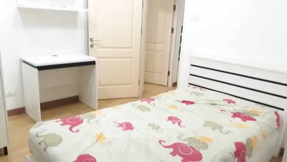 Cozy bedroom with single bed and desk, ideal for a child's room.