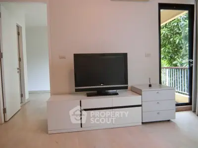 Modern living room with sleek TV stand and balcony view