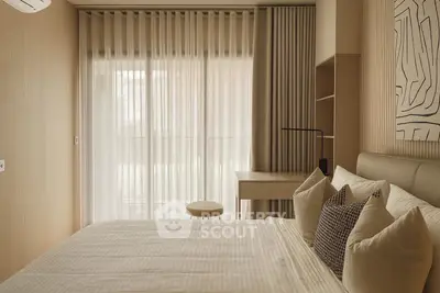 Elegant bedroom with modern decor and natural light through sheer curtains.