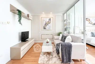 Modern living room with elegant decor and natural light, featuring a cozy sofa and stylish TV unit.