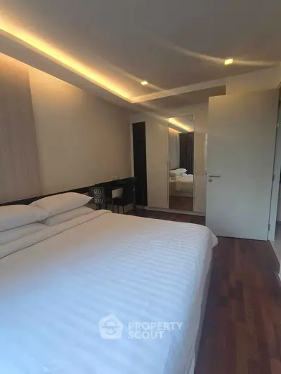 Modern bedroom with elegant lighting and hardwood floors