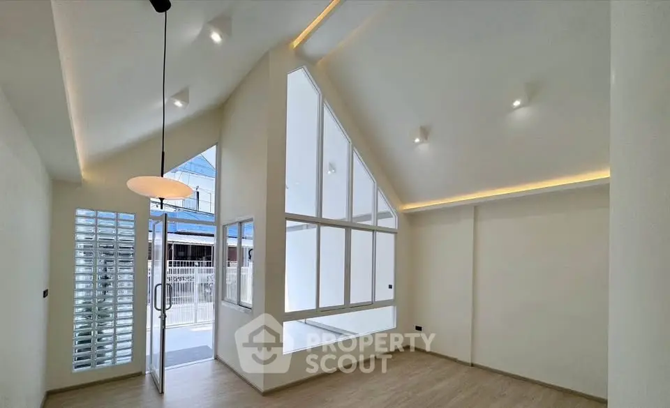 Modern minimalist living room with high ceilings and large windows