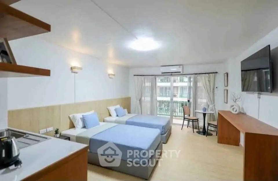 Modern bedroom with twin beds, balcony view, and stylish decor in a spacious apartment.