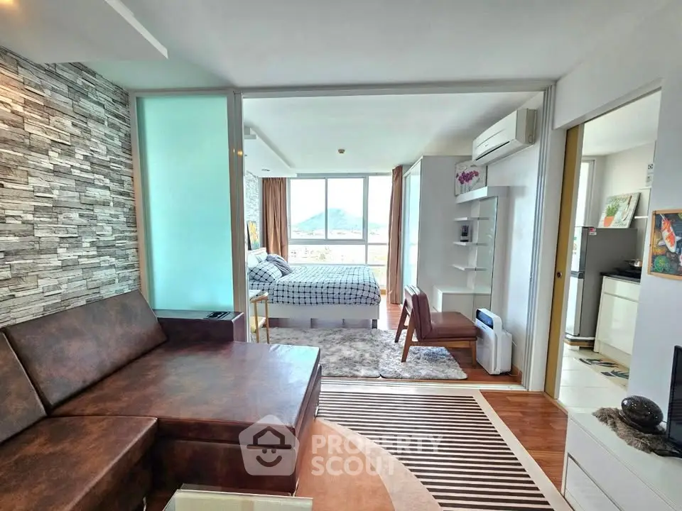 Modern open-layout apartment with stylish living room and bedroom, featuring a scenic view.
