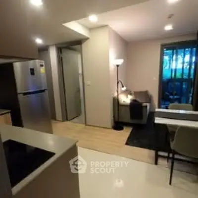 Modern open-plan living room with sleek kitchen and cozy seating area.