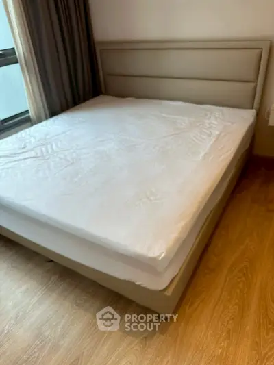 Spacious bedroom with modern bed and wooden flooring, perfect for comfort and style.