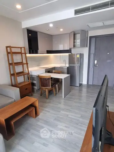 Modern open-layout kitchen with sleek cabinetry and dining area in stylish apartment.